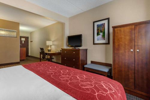 a hotel room with a bed and a flat screen tv at Comfort Suites Green Bay West in Green Bay