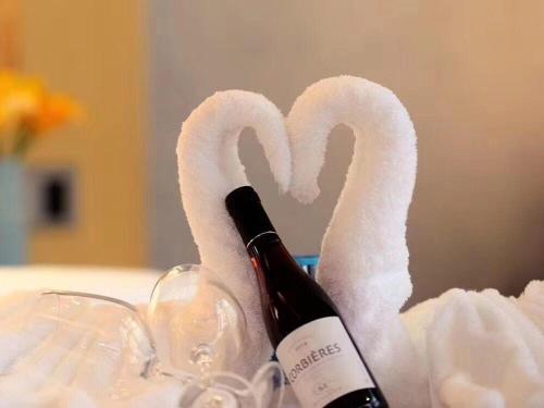 a bottle of wine and two swan paper towels at Lavande Hotel Shanghai Jiading Xincheng Stadium Branch in Jiading