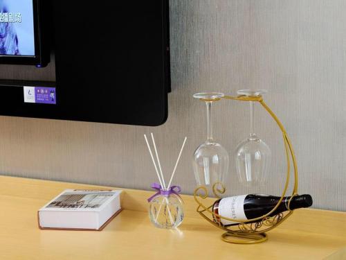 a table with a bottle of wine and two wine glasses at Lavande Hotel Shanghai Jiading Xincheng Stadium Branch in Jiading