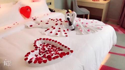 a white bed with red hearts on it at Lavande Hotel Shanghai Jiading Xincheng Stadium Branch in Jiading
