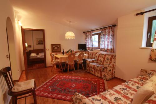 a living room with a table and a couch at Residence Salvan in Corvara in Badia