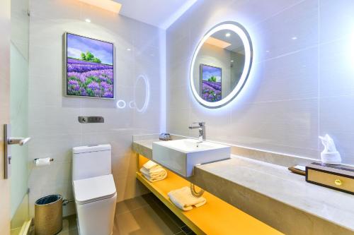 ein Bad mit einem Waschbecken und einem Spiegel in der Unterkunft Lavande Hotel Shanghai Jiading Xincheng Stadium Branch in Jiading