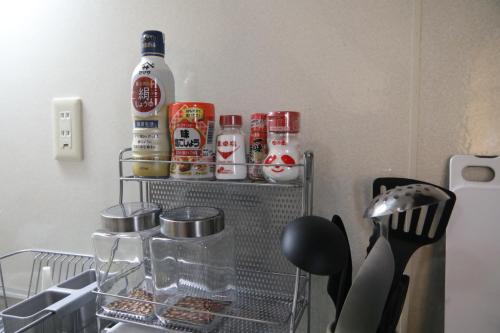 a shelf in a kitchen with spices and a bottle at Stay Omihachiman Ekimae Inn in Omihachiman
