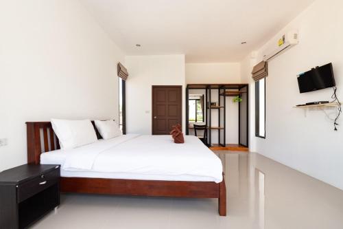 - une chambre avec un lit et une télévision murale dans l'établissement D-Valley, Koh S@mui, à Choeng Mon Beach
