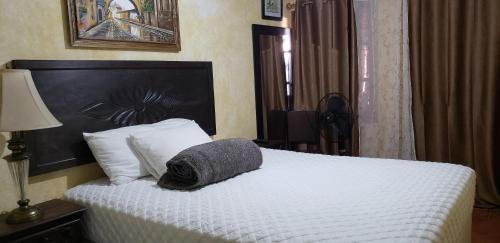 a bedroom with a white bed with a pillow on it at Hotel Real Antigua in Antigua Guatemala