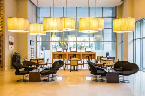 a restaurant with tables and chairs and large windows at ibis Deira Creekside Dubai in Dubai