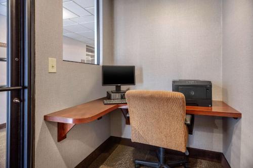 a room with a desk with a computer and a chair at Comfort Suites Green Bay West in Green Bay