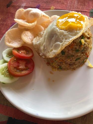 a plate of food with an egg and some chips at Leokap Homestay in Tuk Tuk