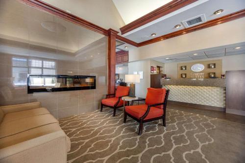 a hotel room with a couch and a table and chairs at Comfort Suites Green Bay West in Green Bay
