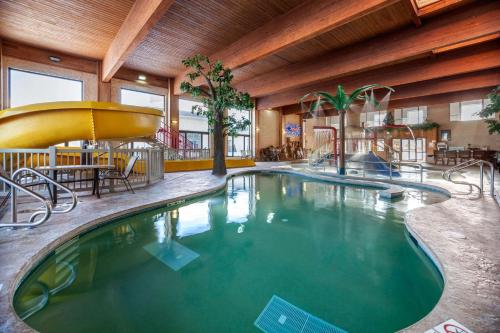 a large swimming pool in a building with a restaurant at Comfort Suites Green Bay West in Green Bay