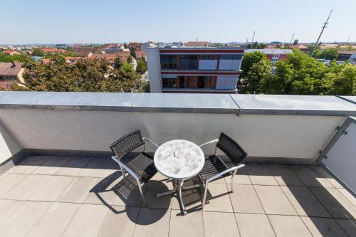 a table and chairs on the roof of a building at Novina Hotel Tillypark in Nürnberg
