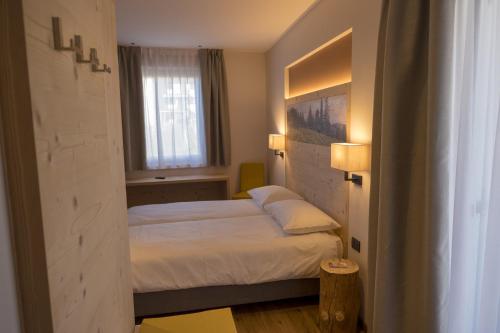 a bedroom with two beds and a window at Agritur Piccolo Fiore B&B in Taio