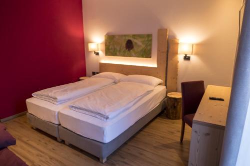 a bedroom with two beds in a red room at Agritur Piccolo Fiore B&B in Taio