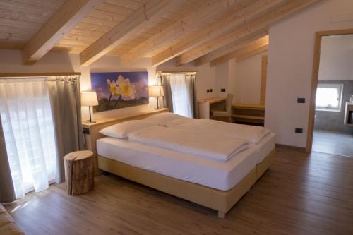 a bedroom with a large bed in a room at Agritur Piccolo Fiore B&B in Taio