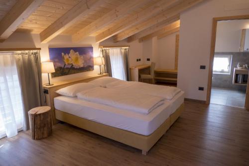 a bedroom with a large bed in a room at Agritur Piccolo Fiore B&B in Taio