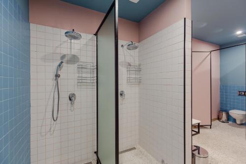 a bathroom with a shower with pink and blue tiles at Back2ME in Batumi