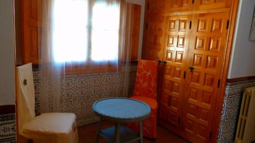 a room with two stools and a door with a window at Las mil y una noches in Tramacastilla