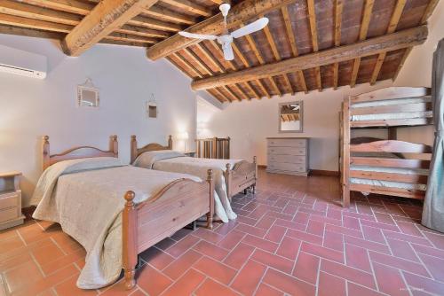 a bedroom with two beds and a wooden ceiling at Agriturismo La Gioconda in Vinci