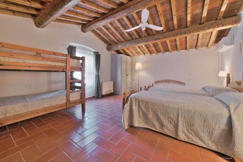 a bedroom with two beds and a ceiling fan at Agriturismo La Gioconda in Vinci