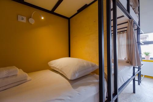 two bunk beds in a room with yellow walls at Back2ME in Batumi