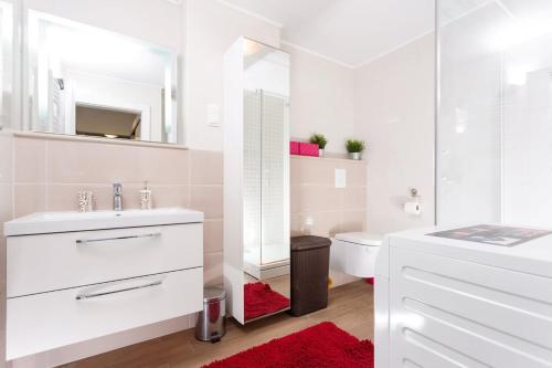 Baño blanco con lavabo y aseo en Apartment Gazo, en Trogir