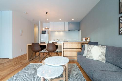 a living room with a couch and a kitchen at ROKU by H2 Life in Kutchan