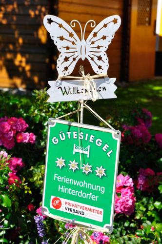 a sign with a butterfly on top of a garden at Ferienwohnung Hinterdorfer in Unterweissenbach