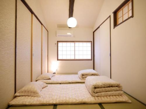 - 3 lits dans une chambre avec fenêtre dans l'établissement Nice Kyoto, à Kyoto
