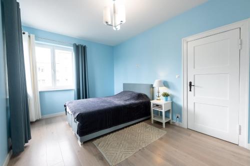 ソポトにあるVictus Apartamenty, Apartament Romaの青いベッドルーム(ベッド1台、窓付)