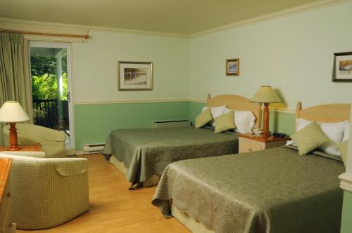 a hotel room with two beds and a window at Hôtel au Petit Berger in La Malbaie