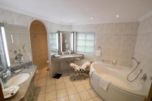 uma grande casa de banho com banheira e lavatório em Landhotel der Schafhof Amorbach em Amorbach