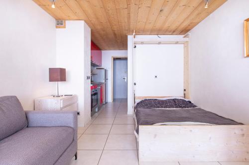 a living room with a couch and a bed at Résidence Le Borsat - Tignes Val Claret in Tignes