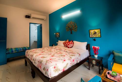 a bedroom with a bed in a blue wall at Coral Country Homestay in Agra