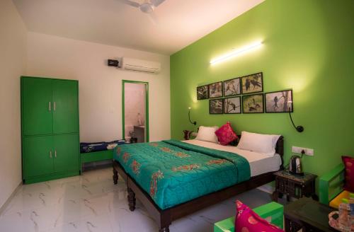 a green bedroom with a bed and green cabinets at Coral Country Homestay in Agra