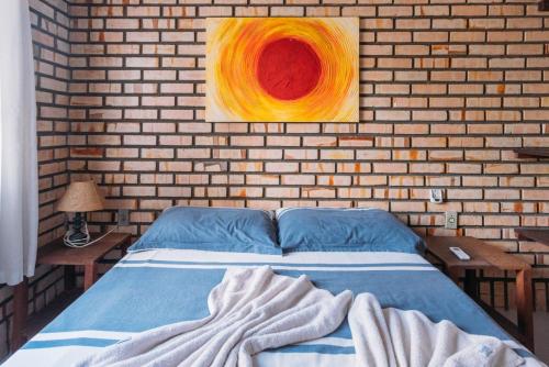 um quarto com uma cama e um quadro na parede em Pousada Canto das Trilhas em Bombinhas
