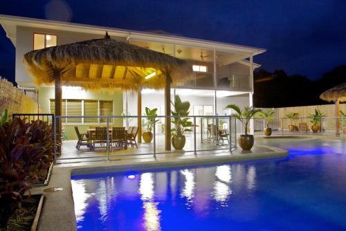 a swimming pool with a balcony and a balcony umbrella at The Coast Motel in Yeppoon