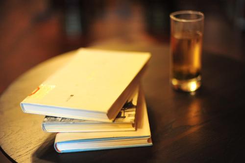 a stack of books on a table next to a glass at Nordic Memory in Qingdao in Qingdao