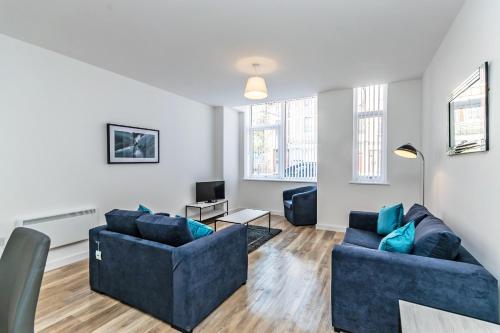 a living room with two blue couches and a tv at City Suites in Chester