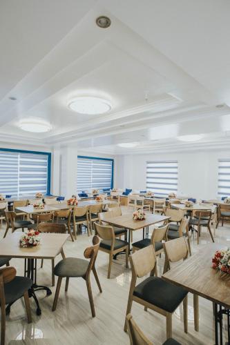 a large room with tables and chairs and windows at Santiago Cove Hotel and Restaurant in Santiago