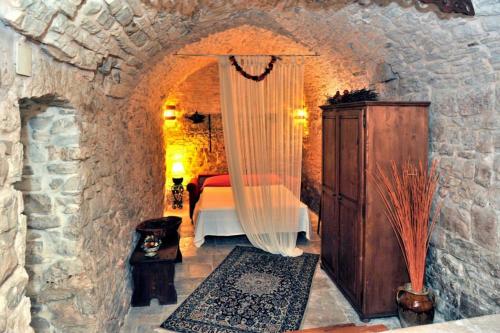 a bedroom with a bed in a stone wall at Corte Sagarriga Visconti in Giovinazzo