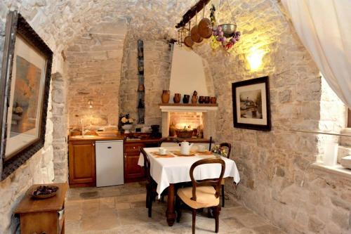 una cocina con mesa en una cocina con paredes de piedra en Corte Sagarriga Visconti, en Giovinazzo