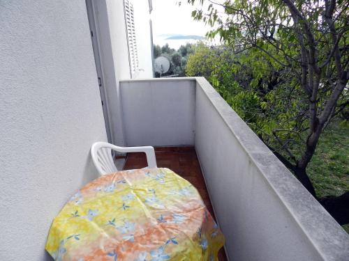 a chair sitting on a balcony with a table at Apartments Senny in Orebić