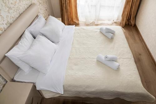 Una cama con almohadas blancas y toallas. en Batumi Orbi Residence Lux en Batumi