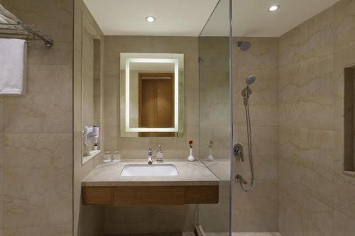 a bathroom with a sink and a shower at Nataraj Sarovar Portico in Jhānsi
