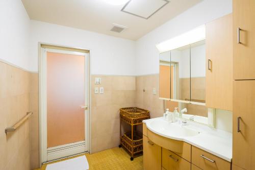 a bathroom with a sink and a mirror at Hotel Sun Garden Matsuyama in Matsuyama