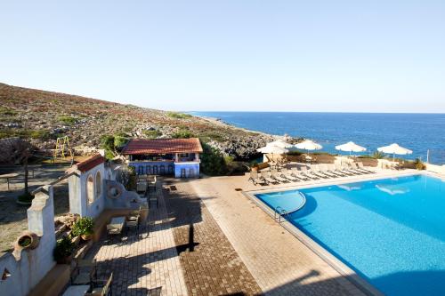 a view of a swimming pool and the ocean at Giorgi's Blue Apartments in Kalathas
