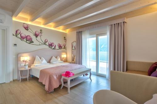 a bedroom with a bed with a flower mural on the wall at Hotel Riviera Panoramic Green Resort in Limone sul Garda