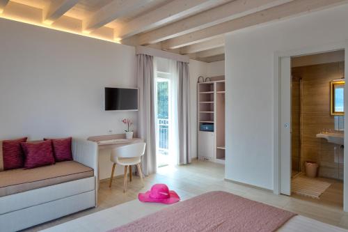 a living room with a couch and a table with a pink hat at Hotel Riviera Panoramic Green Resort in Limone sul Garda