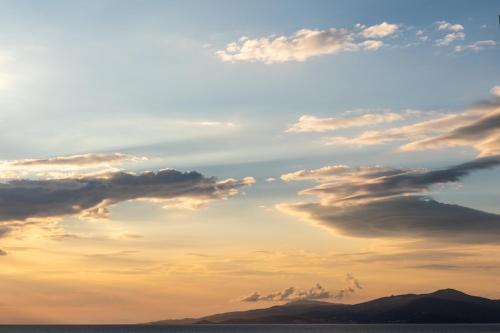 a cloudy sky over the ocean at sunset at Magic View Suites Mykonos in Mýkonos City