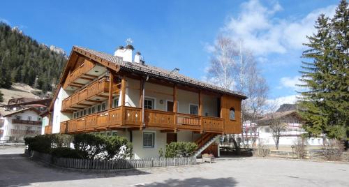 a house with a balcony on top of it at Casa El Tobià in Pozza di Fassa